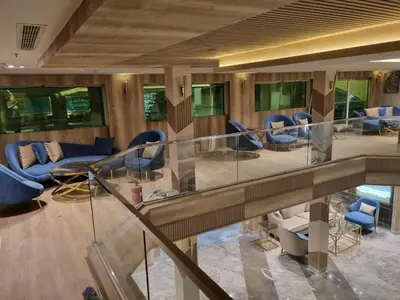 a lobby with blue chairs and a glass staircase at Nile Cruise 3 & 4 & 7 Nights in Luxor