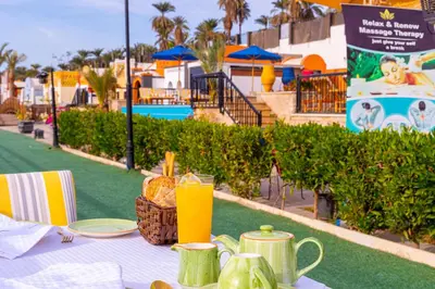a table with a plate of food and drinks on it at Sonesta Nouba Hotel Aswan in Aswan