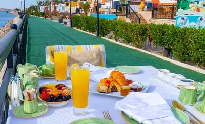 a table with food and glasses of orange juice at Sonesta Nouba Hotel Aswan in Aswan