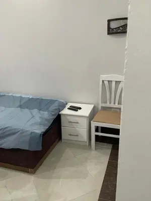 a small bedroom with a bed and a chair at Schöne Ferienwohnung in Cecelia Resort, am Pool und wunderschönen Strand für Familien und Paare in Hurghada