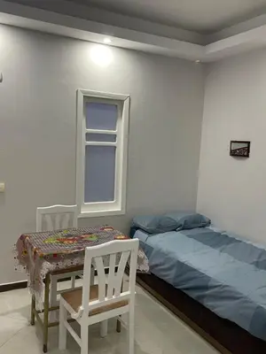 a bedroom with a bed and a table and a chair at Schöne Ferienwohnung in Cecelia Resort, am Pool und wunderschönen Strand für Familien und Paare in Hurghada