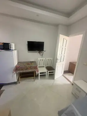 a living room with a table and a tv on the wall at Schöne Ferienwohnung in Cecelia Resort, am Pool und wunderschönen Strand für Familien und Paare in Hurghada