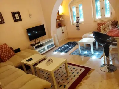 a living room with a couch and a tv at Down-Town Kafr El Gouna 1-Bd Ground Floor in El Gouna