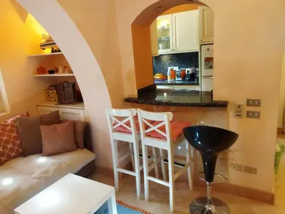 a living room with a couch and a kitchen at Down-Town Kafr El Gouna 1-Bd Ground Floor in El Gouna