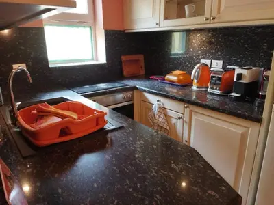 a kitchen with a black counter top with an orange bin on the counter at Down-Town Kafr El Gouna 1-Bd Ground Floor in El Gouna
