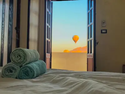 a bedroom with a bed with a view of a hot air balloon at sun smile guest house᭄ꦿ in Luxor