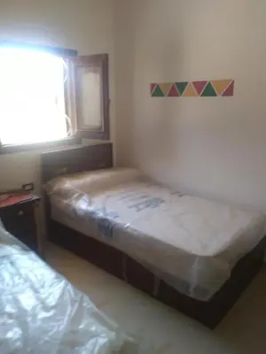 a small bedroom with two beds and a window at النبلاء جيست هاوس نوبيان اسوان in Aswan