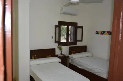 a room with two beds and a mirror and a window at النبلاء جيست هاوس نوبيان اسوان in Aswan