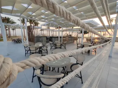 a balcony with tables and chairs on a cruise ship at Casa Blue Resort in Marsa Alam City