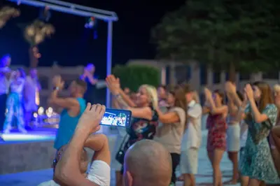 a man taking a picture of a group of people dancing at Casa Blue Resort in Marsa Alam City