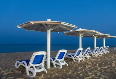 a row of chairs and umbrellas on a beach at Casa Blue Resort in Marsa Alam City