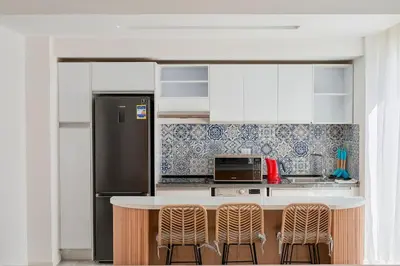a kitchen with a refrigerator and a counter with stools at 3bedroom apartment with a private pool in Hurghada