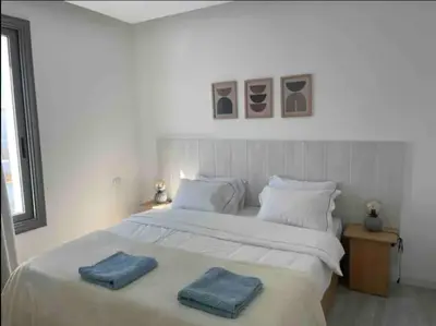 a bedroom with a large white bed with two blue towels on it at 3bedroom apartment with a private pool in Hurghada