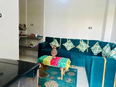 a blue couch with pillows and a table in a living room at Nubian Bride guest house in Aswan
