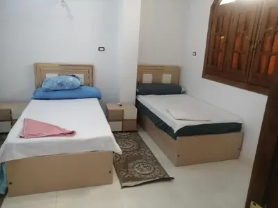 two beds in a room with boxes on the floor at Nubian Bride guest house in Aswan
