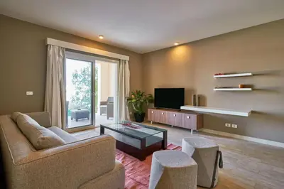 a living room with a couch and a tv at Ground floor two bedrooms in Joubal Lagoon with direct pool access and view in Hurghada