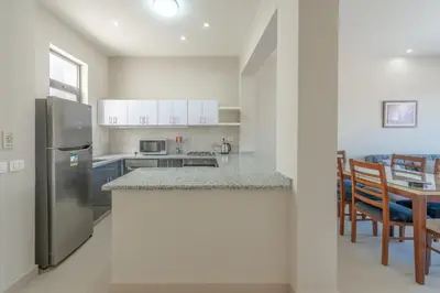a kitchen with a stainless steel refrigerator and a table at Brand-New Family House in Tawila El Gouna Lagoon and Pool Access in Hurghada