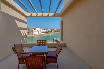 a dining room with a table and chairs and a large window at Brand-New Family House in Tawila El Gouna Lagoon and Pool Access in Hurghada