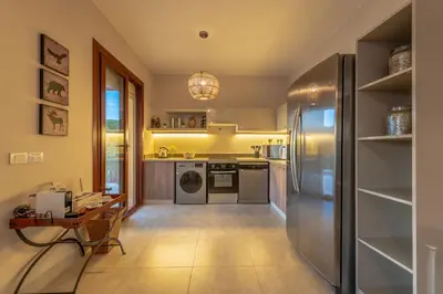a kitchen with a stainless steel refrigerator and a table at BYTK - La Casa Del Sol in Hurghada