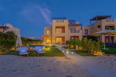 a house on the beach with two chairs and a table at BYTK - La Casa Del Sol in Hurghada