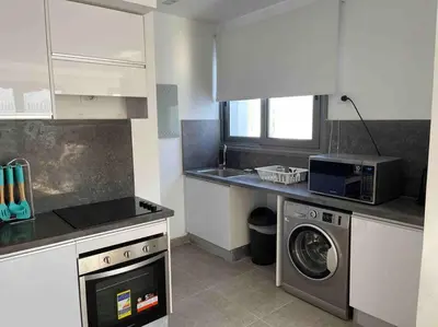 a kitchen with a washing machine and a microwave at 2 bd with private heated pool in Sholan 2 El Gouna in Hurghada