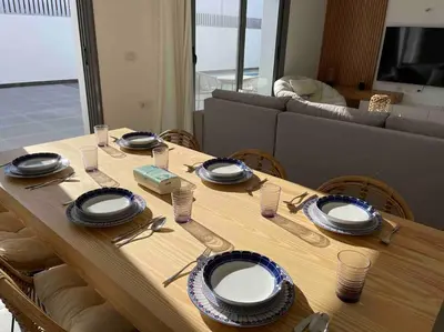 a wooden table with plates and utensils on it at 2 bd with private heated pool in Sholan 2 El Gouna in Hurghada