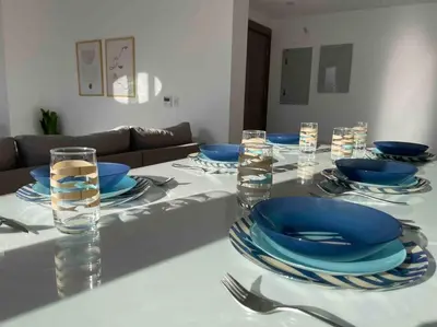 a white table with blue plates and glasses on it at 3bd with a private heated pool in Sholan 2 ElGouna in Hurghada