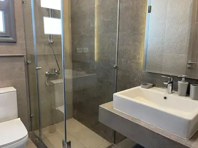 a bathroom with a shower and a sink and a toilet at 2 bedroom with a private heated pool in Sholan2 in Hurghada