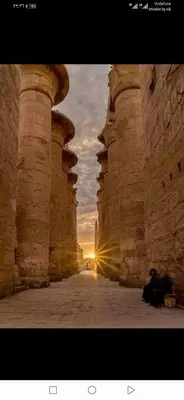 an archway of a building with a sunset in the background at Luxor Nile palace in Luxor