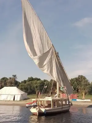 a sail boat with a man on it in the water at Nile Felucca Adventure in Aswan