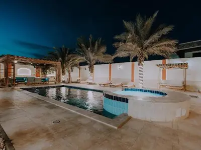 a swimming pool with palm trees in a building at Luxury private villa with pool in Hurghada