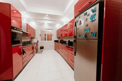 a kitchen with red cabinets and a stainless steel refrigerator at Luxury private villa with pool in Hurghada