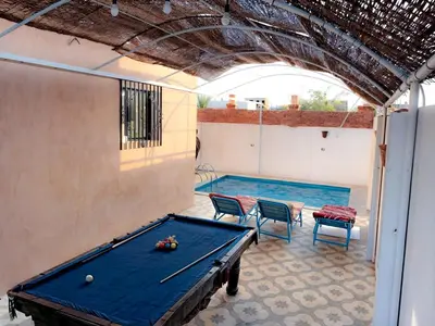 a pool table with two chairs and a pool table at Villa Nile Rayan in Al Aqālitah