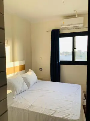 a bedroom with a white bed and a window at Villa Nile Rayan in Al Aqālitah