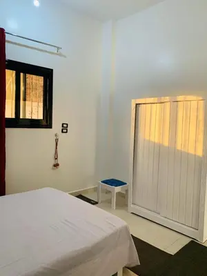 a bedroom with a white bed and a window at Villa Nile Rayan in Al Aqālitah