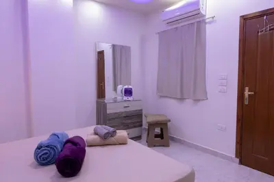 a bedroom with a bed with purple blankets on it at F&M Home Egypt - Apartment Hurghada in Hurghada