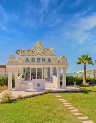 a white entrance to a building with a palm tree at Selena Bay Luxury Resort - Premium Apartment with Private Beach in Hurghada