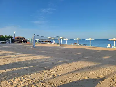 a sandy beach with umbrellas and the ocean at Selena Bay Luxury Resort - Premium Apartment with Private Beach in Hurghada