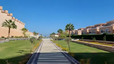 a walkway in a villa yard with palm trees at Selena Bay Luxury Resort - Premium Apartment with Private Beach in Hurghada