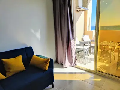 a blue couch in a room with a view of a patio at Sea Dreams @ Hurghada Dreams in Hurghada