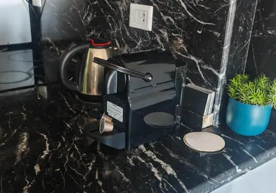 a black coffee maker on a counter with a plant at Sea Dreams @ Hurghada Dreams in Hurghada