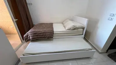 a small white bed in a small room at Casablanca beach resort, first line with private beach and swimming pools, in Hurghada