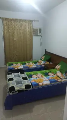two twin beds in a room with at New ikea flat 2 in Hurghada