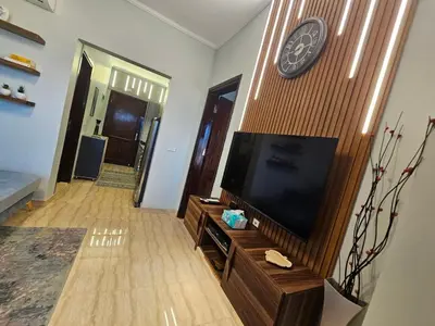 a living room with a tv and a clock on a wall at Hurghada - Apartment Blue Lagoon in Hurghada