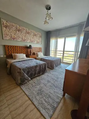 a hotel room with two beds and a desk at Hurghada - Apartment Blue Lagoon in Hurghada