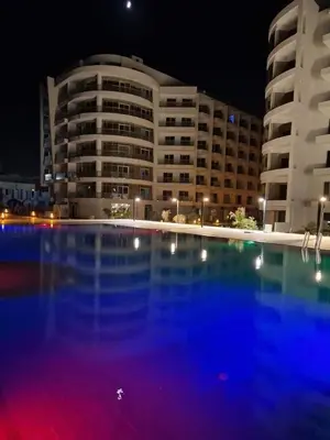a large building with a large swimming pool at night at شقة احلامك علي البحر in Hurghada