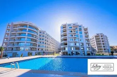 a swimming pool in front of two tall buildings at Orchidia in Hurghada