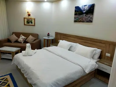 a bedroom with a large bed and a couch at Sweet Home in Hurghada