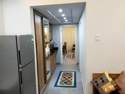 a hallway leading to a kitchen with a refrigerator at Sweet Home in Hurghada