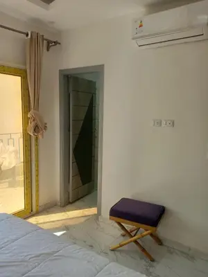 a bedroom with a bed and a bench next to a door at A two-room chalet in the village of Lale Land, Mirage Bay, Ecopark in Hurghada